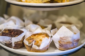 A tray of assorted pastries in paper wrappers.