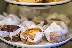 A tray of assorted pastries in paper wrappers.