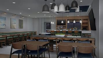 Un restaurante moderno con mesas y sillas de madera, lámparas colgantes y obras de arte en las paredes.