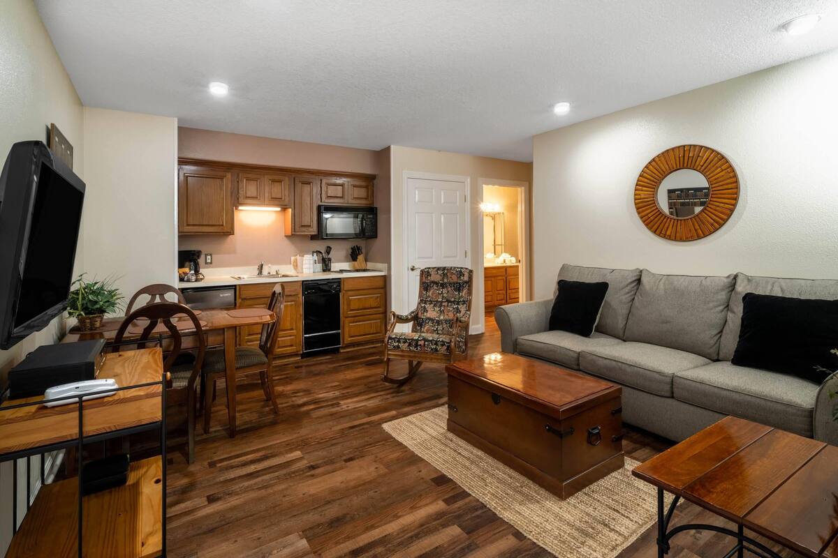 Un salon comprenant un canapé, une table basse et un coin repas avec une table et des chaises.