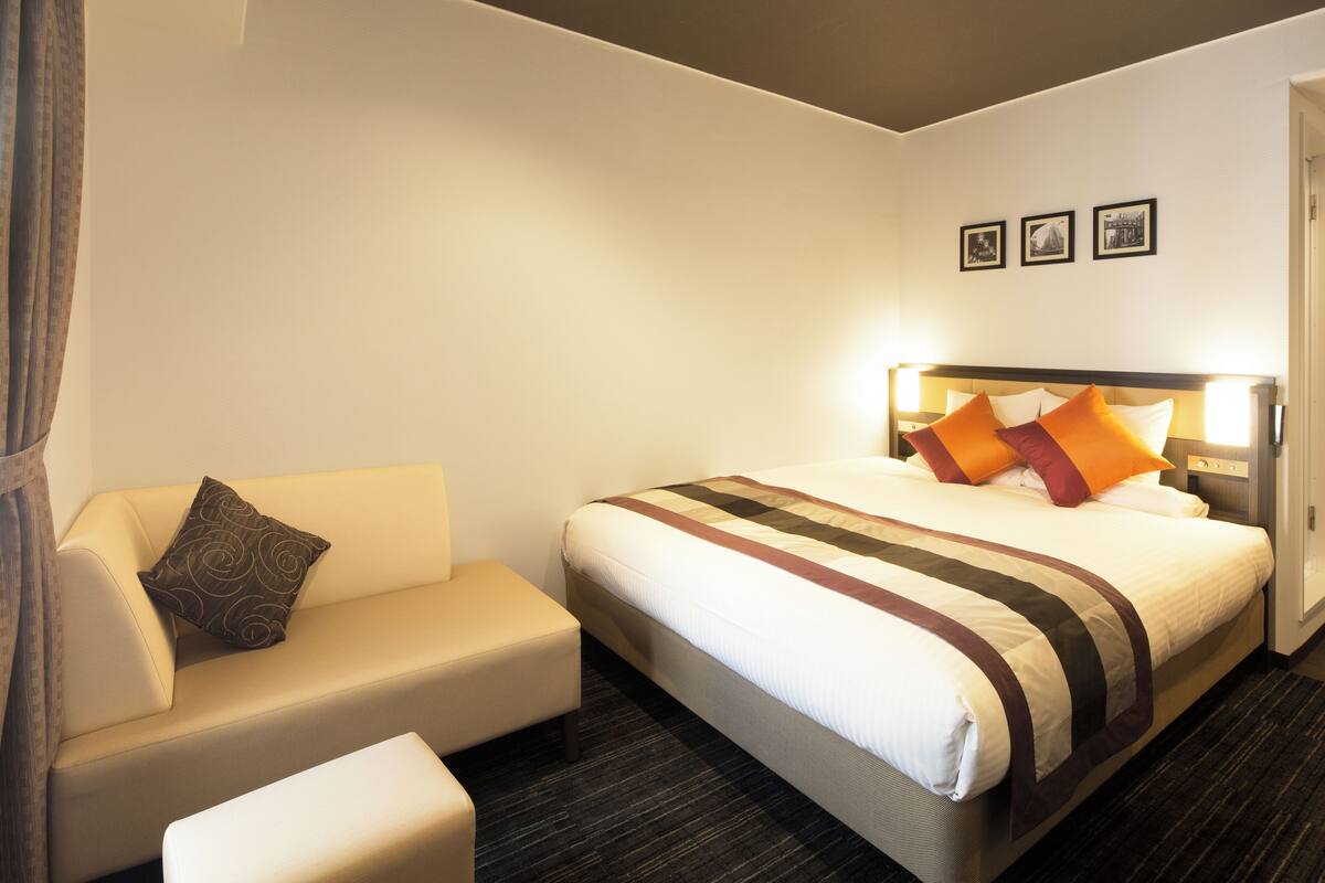 Una habitación de hotel con una cama, un sofá y una mesita.