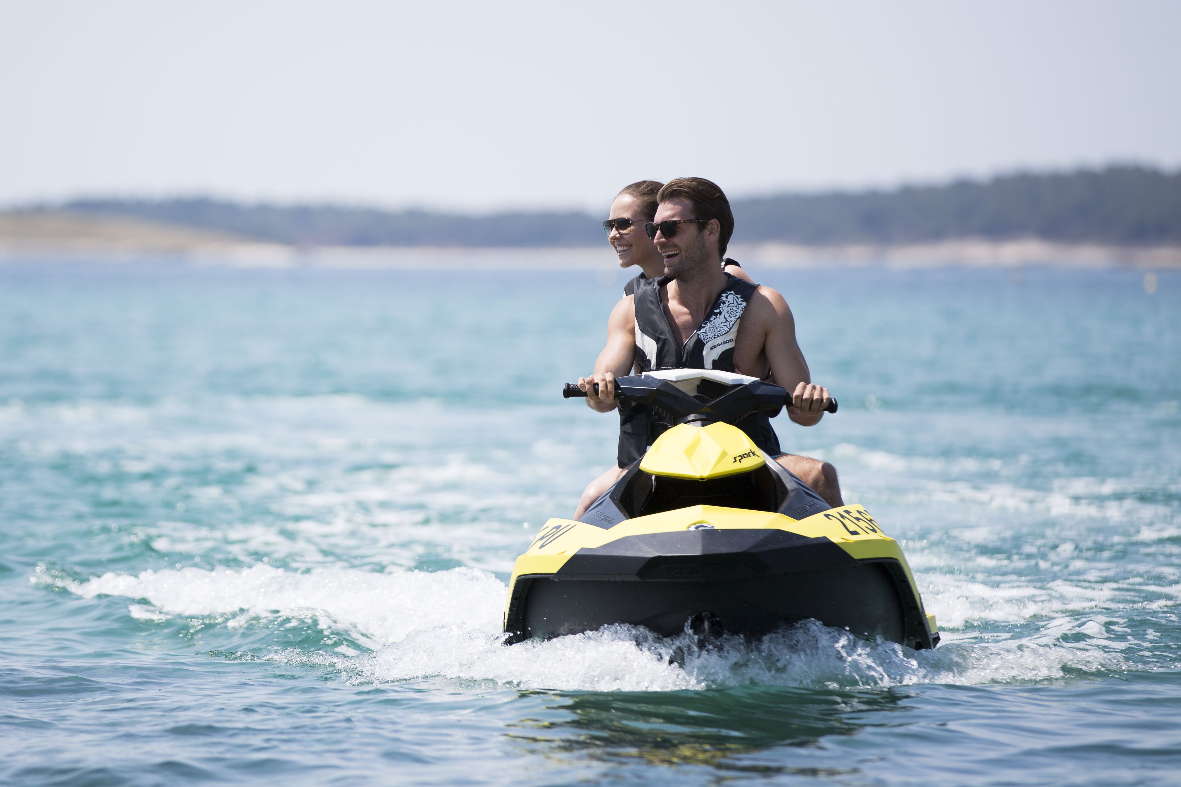 Dos personas paseando en un jet ski sobre el agua.