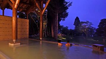 A hot spring area with wooden structures and a bamboo fence.