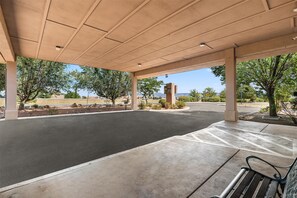 A covered parking area with a bench, trees, and a clear view of the surrounding landscape. - Americas Best Value Inn Prescott Valley (Prescott Valley)