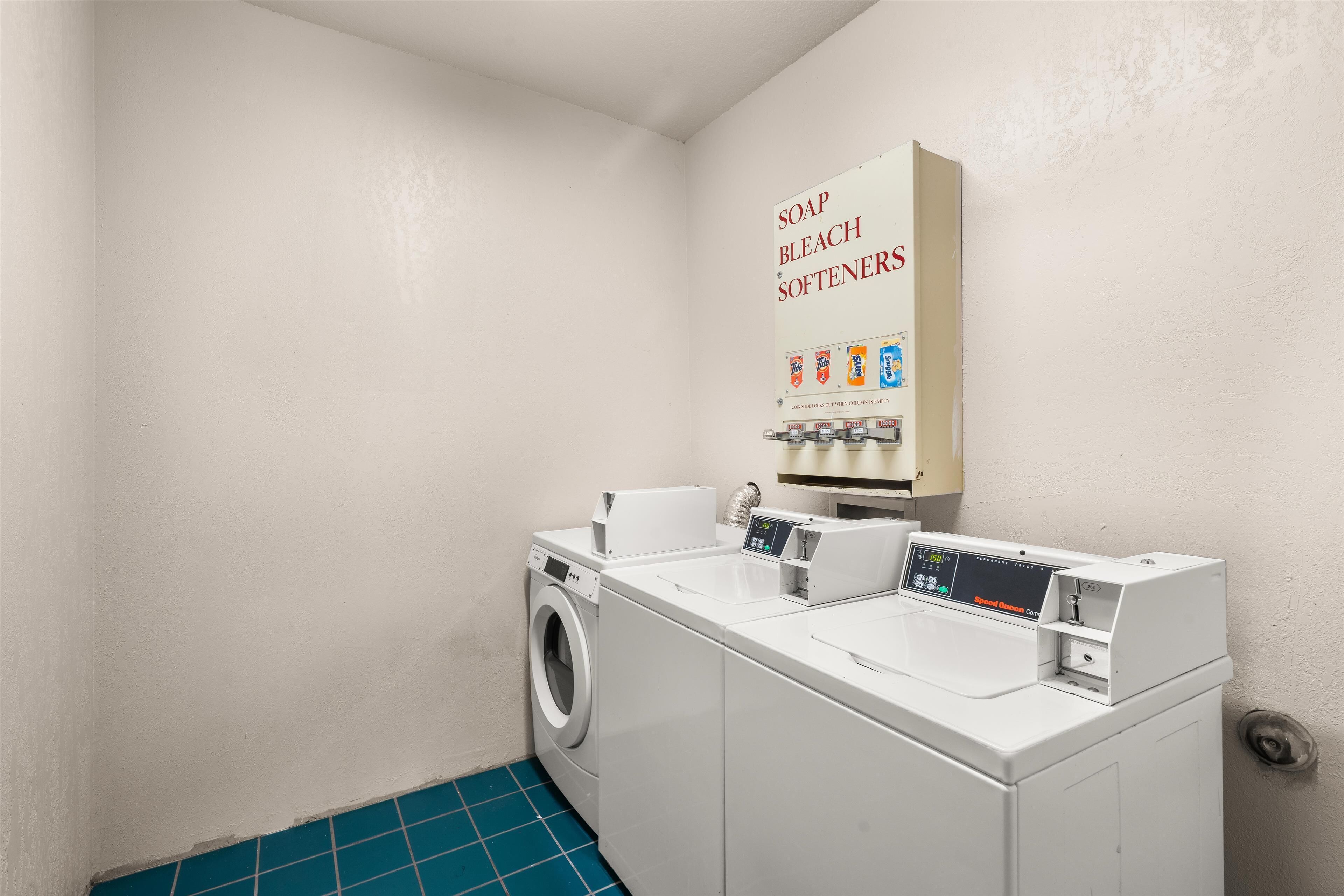 A laundry room with a washing machine, dryer, and a soap, bleach, softeners dispenser.