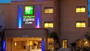 A Holiday Inn Express & Suites building with a prominent illuminated sign, multiple windows, and a clear entrance. - Holiday Inn Express & Suites Woodland Hills by IHG (Woodland Hills)