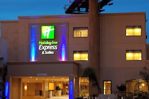 Un bâtiment Holiday Inn Express & Suites, doté d’une enseigne lumineuse bien visible, de nombreuses fenêtres et d’une entrée clairement identifiable.