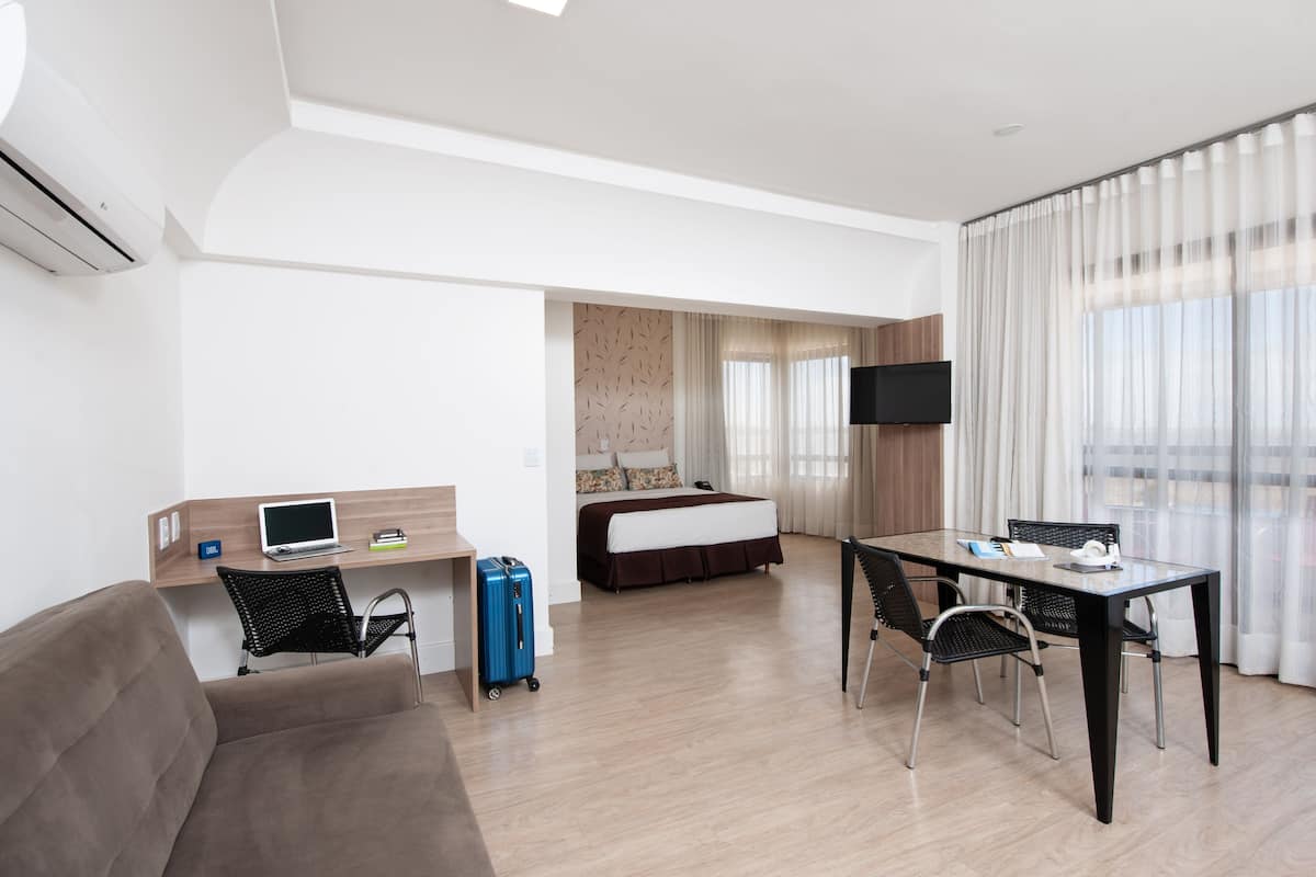 Ein modernes Hotelzimmer mit Bett, Schreibtisch und Sitzecke.