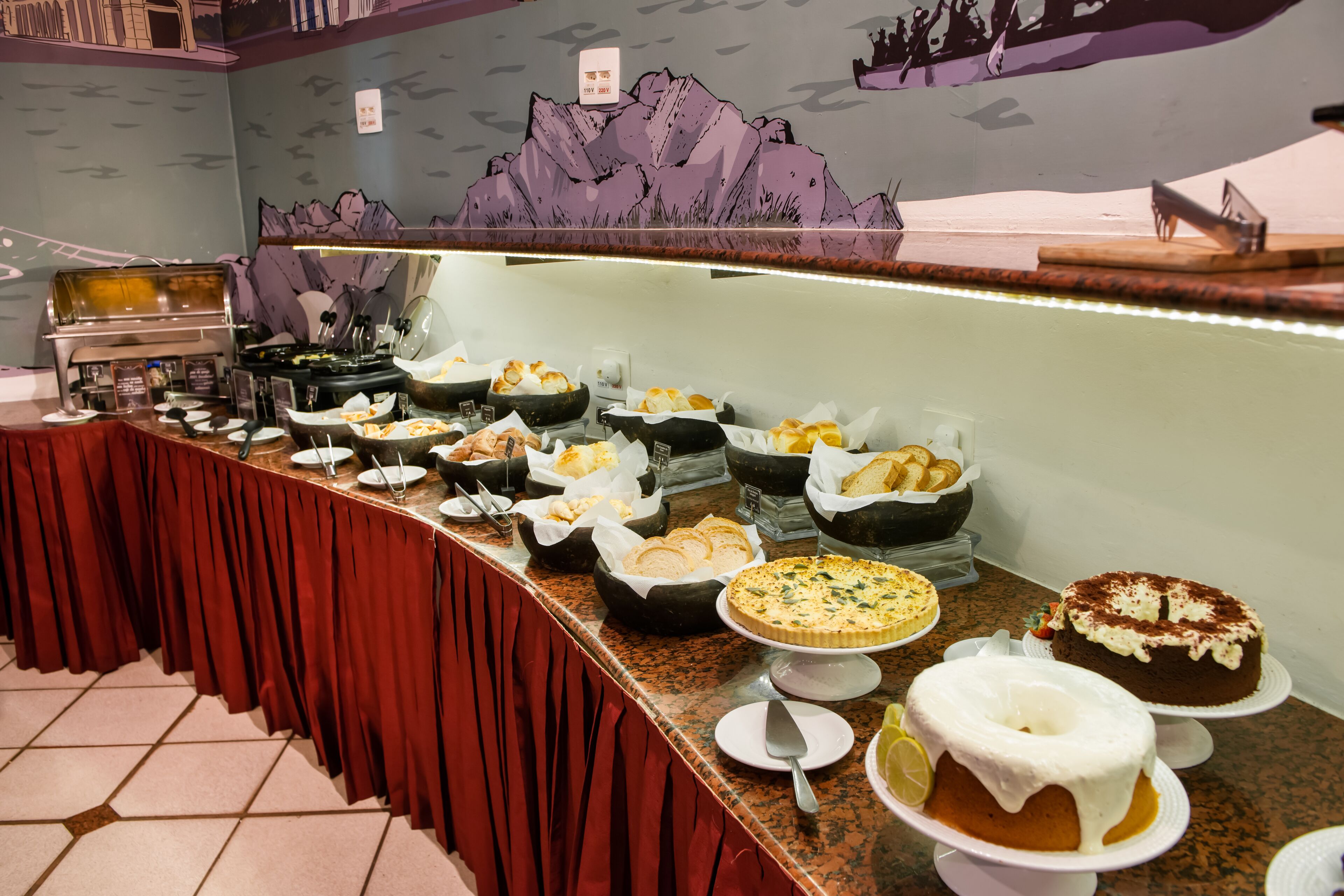A buffet with various dishes and a cake on display.