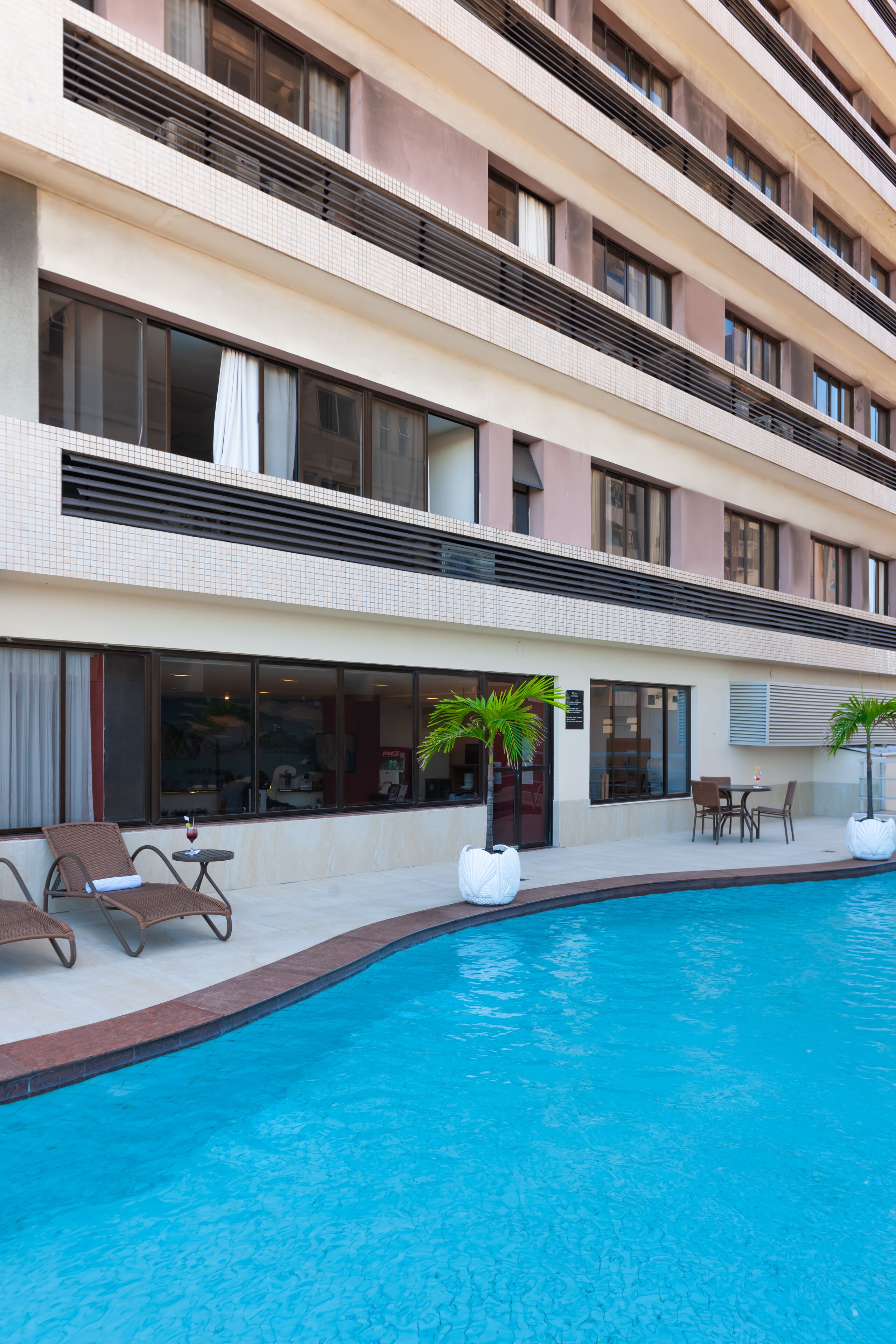 Un hotel con piscina, terraza y varios pisos.