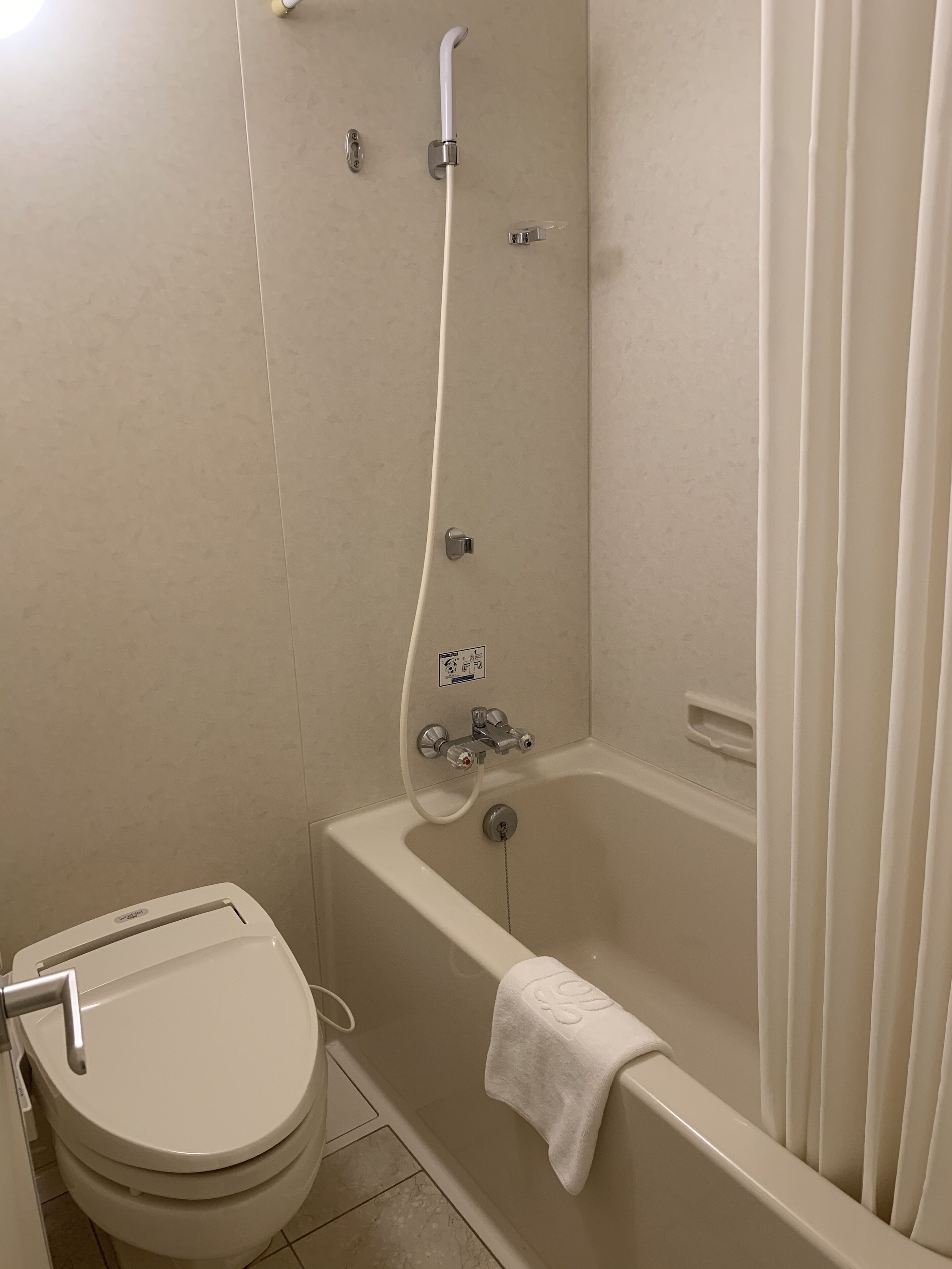 A bathroom with a toilet, a bathtub, and a shower.