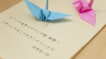 Two origami birds on a piece of paper with Japanese text.