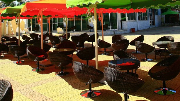 Een hotel met terras en parasols.