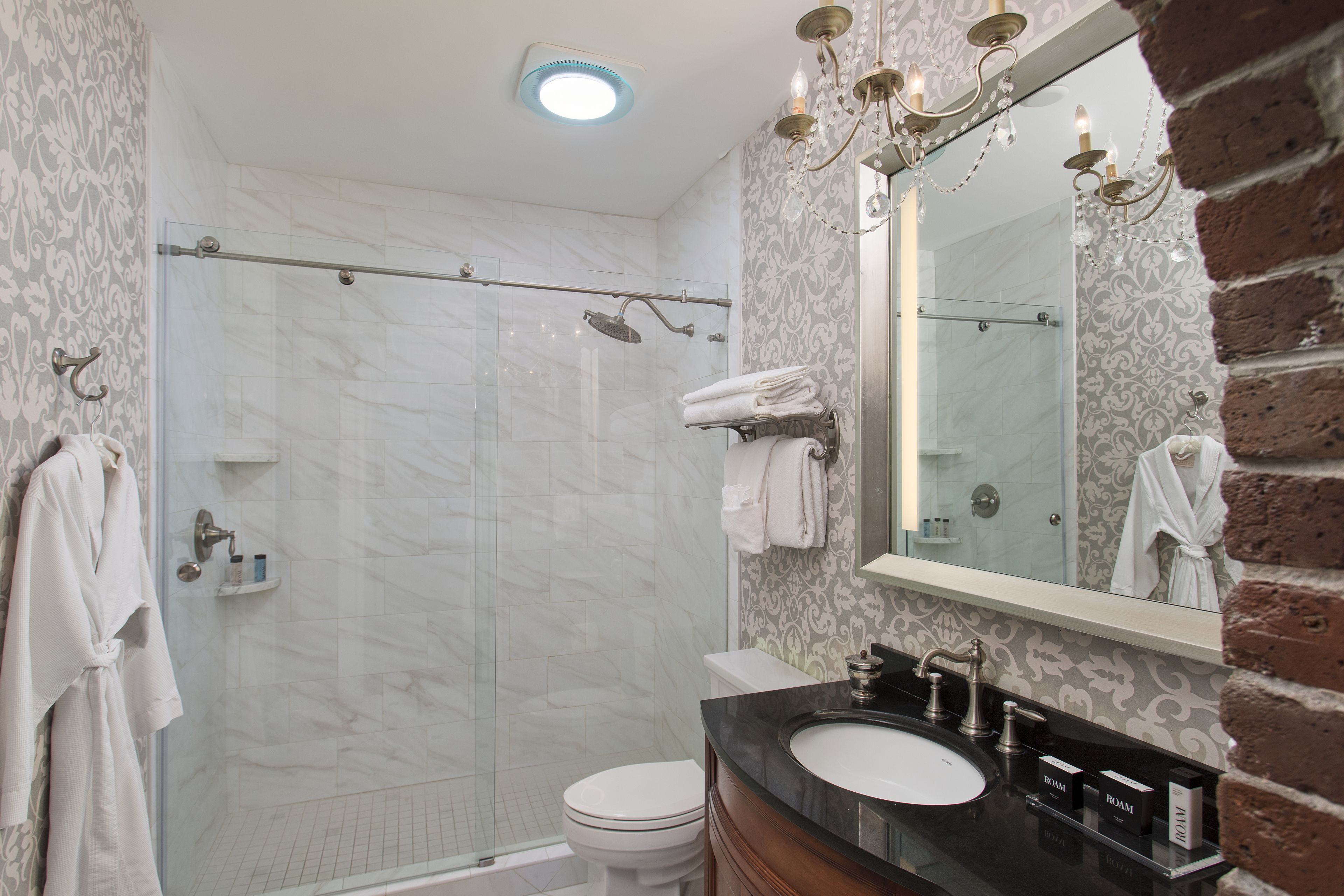 A bathroom with a shower, toilet, and sink.