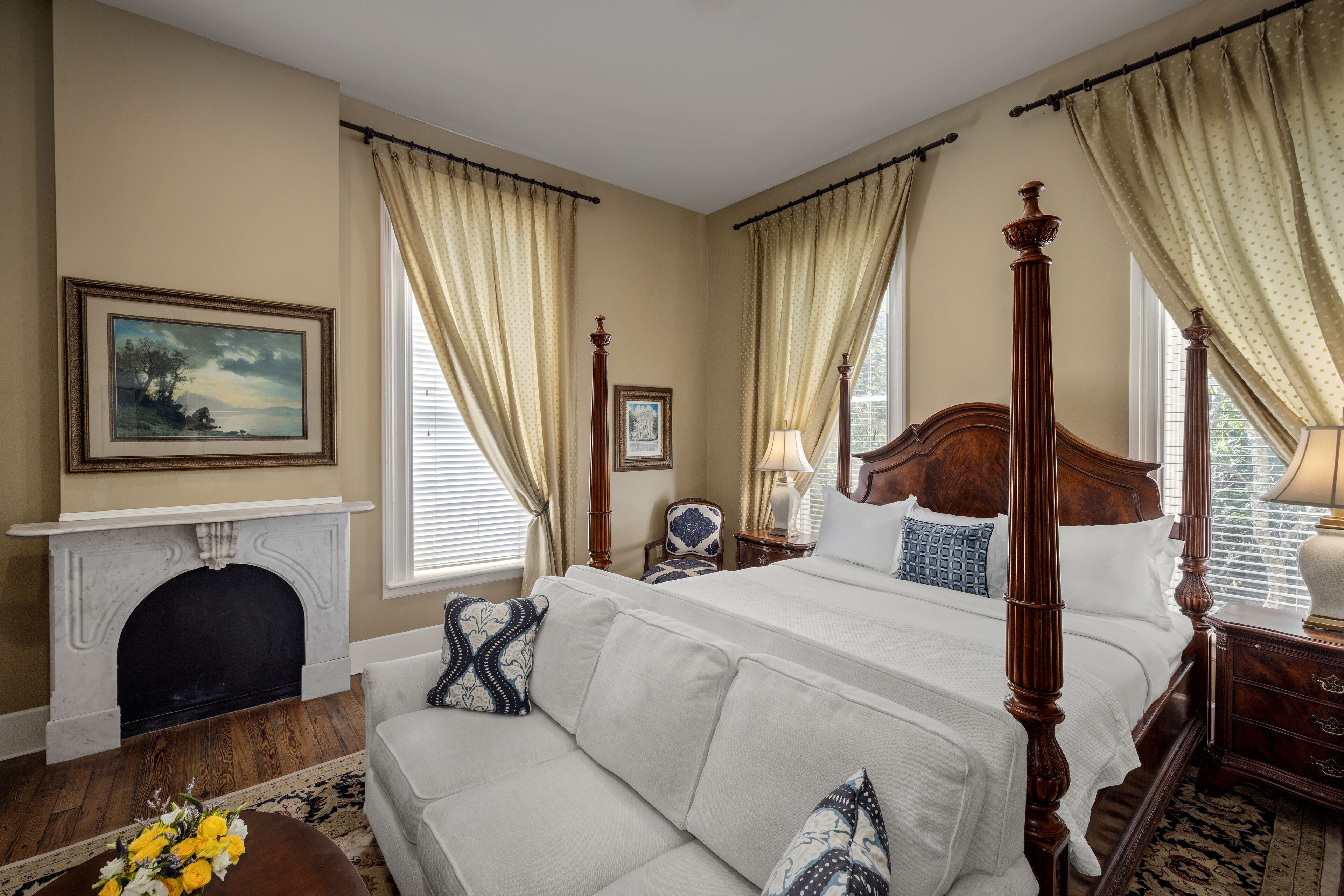 Une chambre spacieuse avec un grand lit, une cheminée et un canapé.