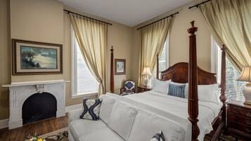 Une chambre spacieuse avec un grand lit, une cheminée et un canapé.