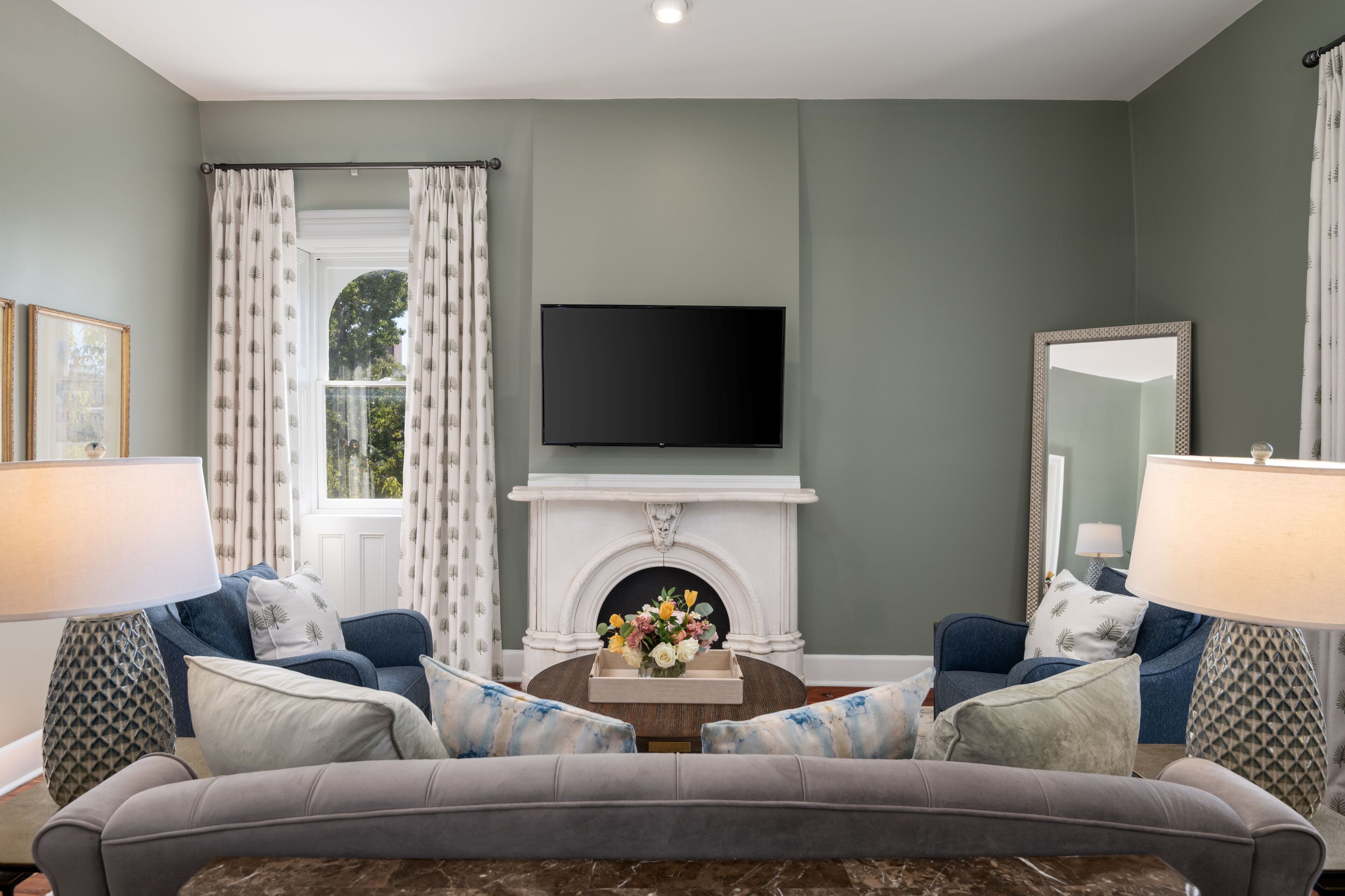 A living room with a fireplace, a flat-screen TV, and two sofas.
