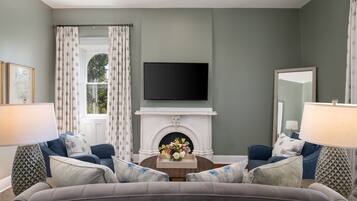 A living room with a fireplace, a flat-screen TV, and two sofas.