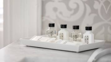Una bandeja con cuatro botellas de crema corporal Grey+Finch sobre una superficie de mármol.