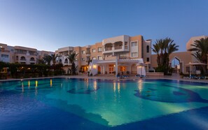 A hotel with a swimming pool, multiple balconies, and palm trees. - Corail Apart’hotel & Splash park (Hammamet)
