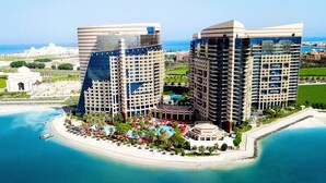 A high-rise hotel with a pool and beachside amenities, overlooking a coastal area. - Khalidiya Palace Rayhaan by Rotana (Abu Dhabi)