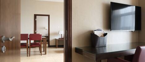 Ein Hotelzimmer mit Bett, Schreibtisch, Stuhl und Fernseher.