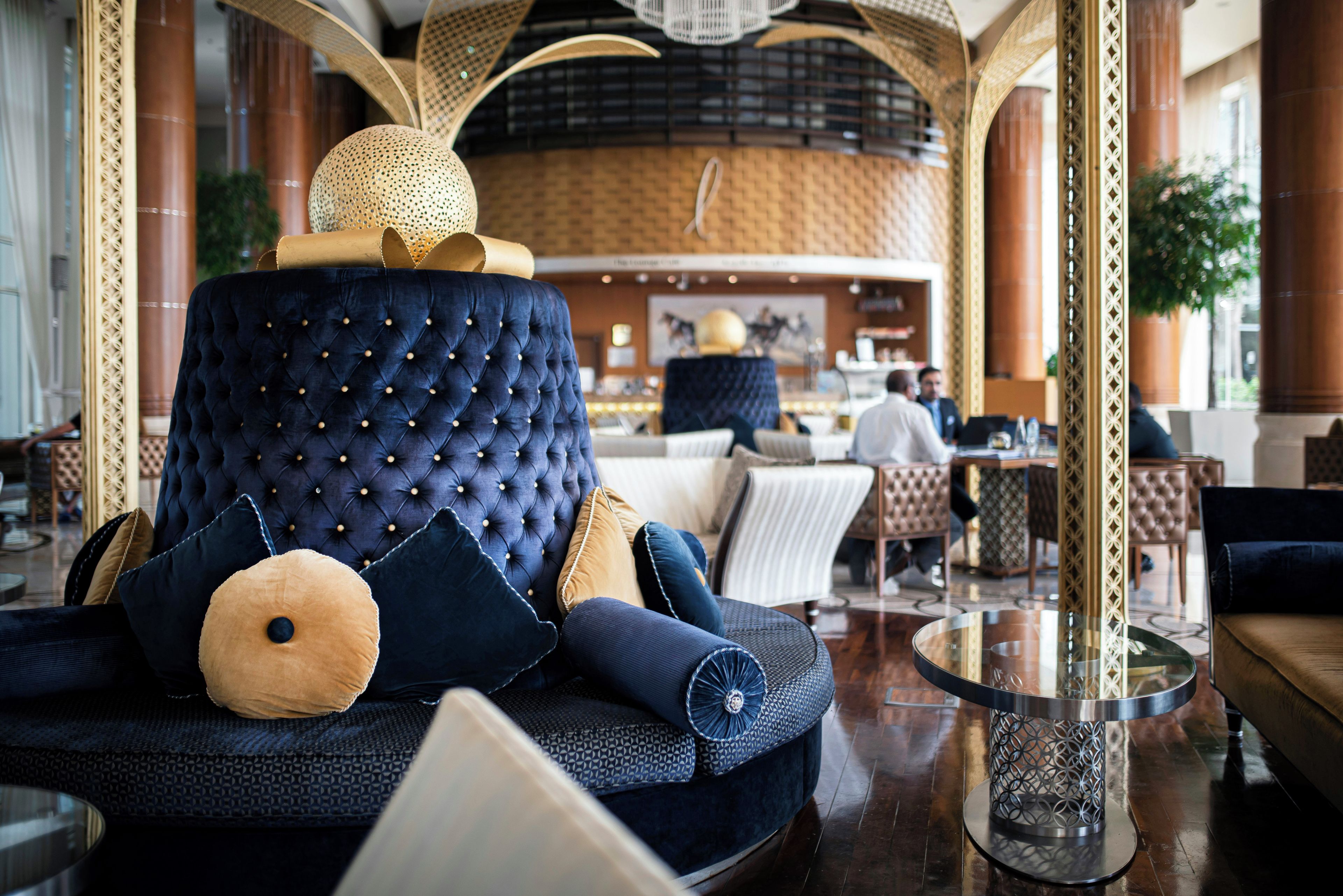 A luxurious seating area with a tufted sofa, decorative pillows, and a glass coffee table.