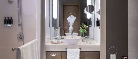 Un baño moderno con ducha, lavabo y espejo.