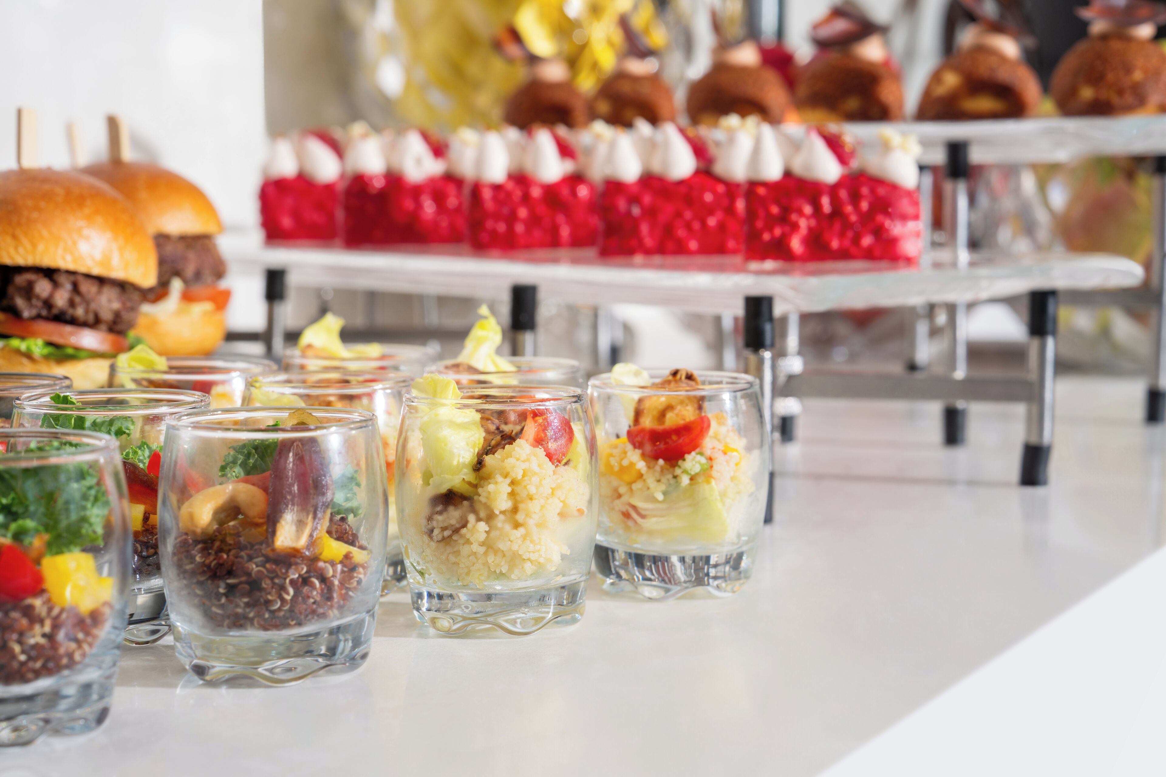 A variety of food items including sandwiches, desserts, and fruit-based drinks on a buffet table.