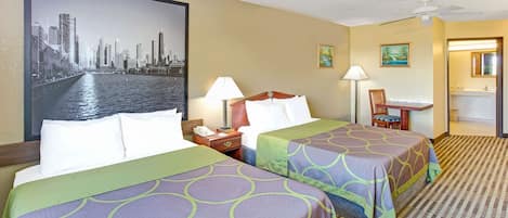 A hotel room with two beds, a desk, a chair, a nightstand, and a large cityscape painting on the wall.
