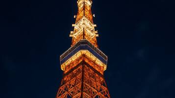A tall, illuminated tower with a complex iron framework and a pointed top.