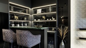 Una cucina moderna con isola centrale, sgabelli da bar e un vaso decorativo.