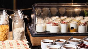A buffet with various food items, including cereals, yogurt, and desserts.