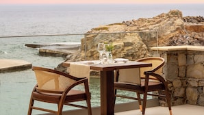 Mesa para dos con vista al océano y terreno rocoso.