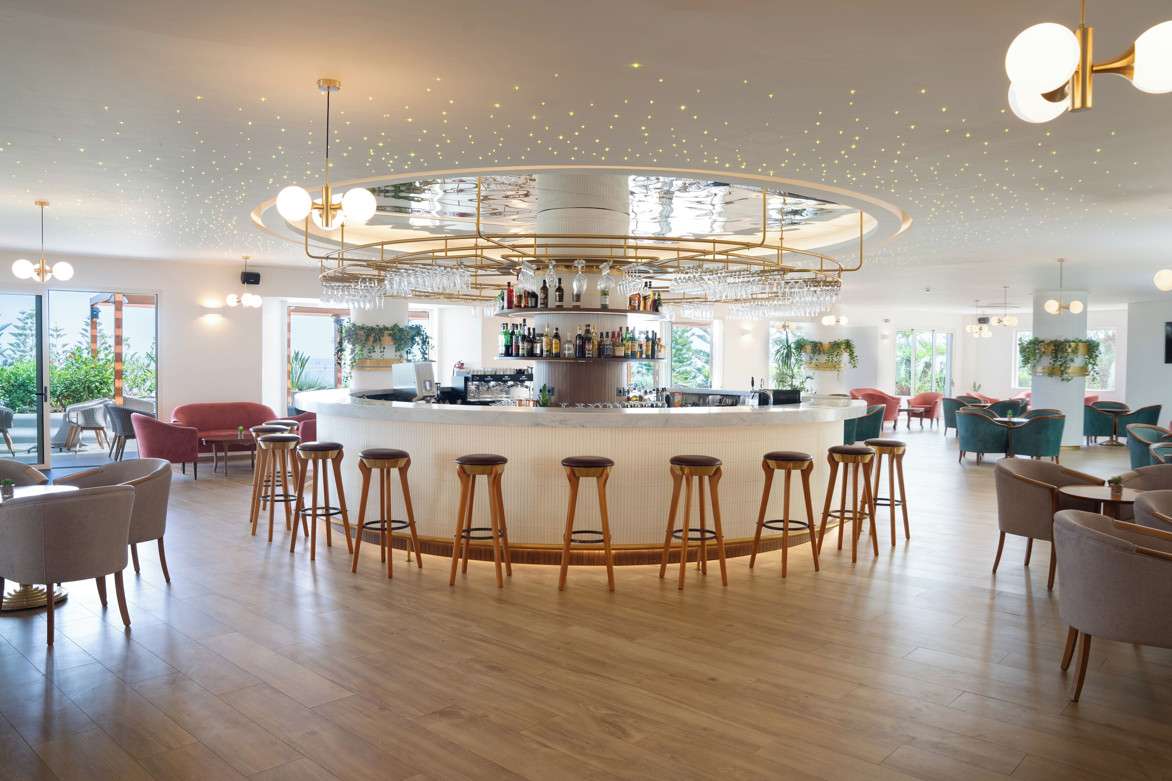 A modern bar area with a central bar counter, multiple stools, and a variety of seating options including bar chairs and round tables.