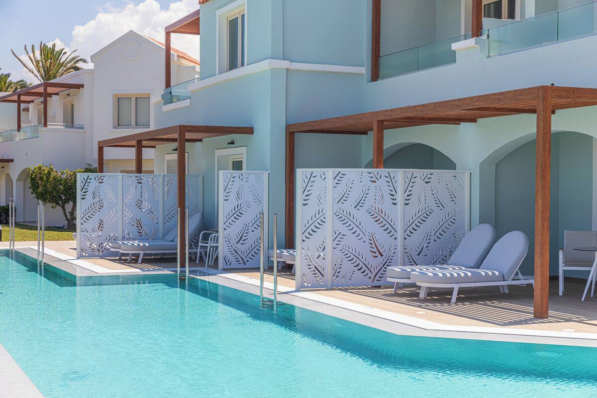 A pool area with lounge chairs and a wooden pergola structure.