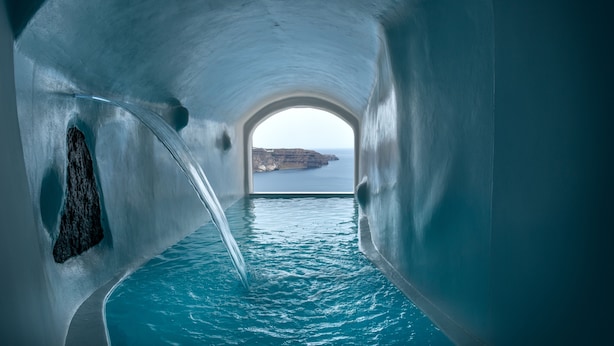 An ice tunnel leading to a pool with a view of a cliff and sea. - Athermi Suites - Adults Only (Santorini)