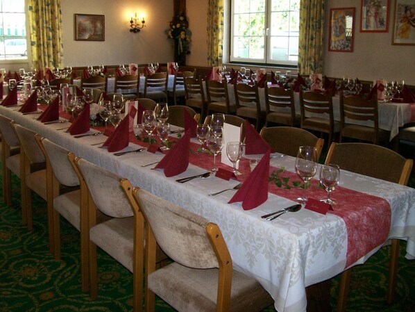 A long dining table set with red napkins, white tablecloths, and chairs. - Attergauhof (Sankt Georgen im Attergau)