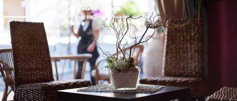 Un conjunto de sillón de mimbre y mesa con una planta en maceta en el centro.