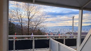 A balcony with a view of a cityscape, including buildings and trees. - Hotel Villa Harmony (Sarajevo)