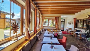 Ein Restaurant mit einer langen Theke, mehreren Tischen und einem Steinboden.