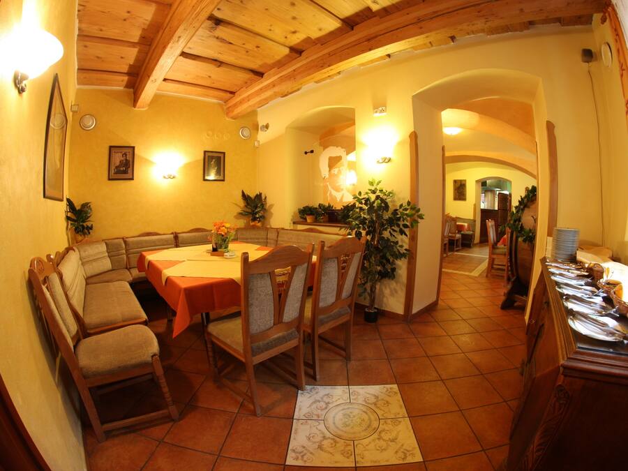 Un comedor con mobiliario de madera, piso de baldosas y ambiente cálido.