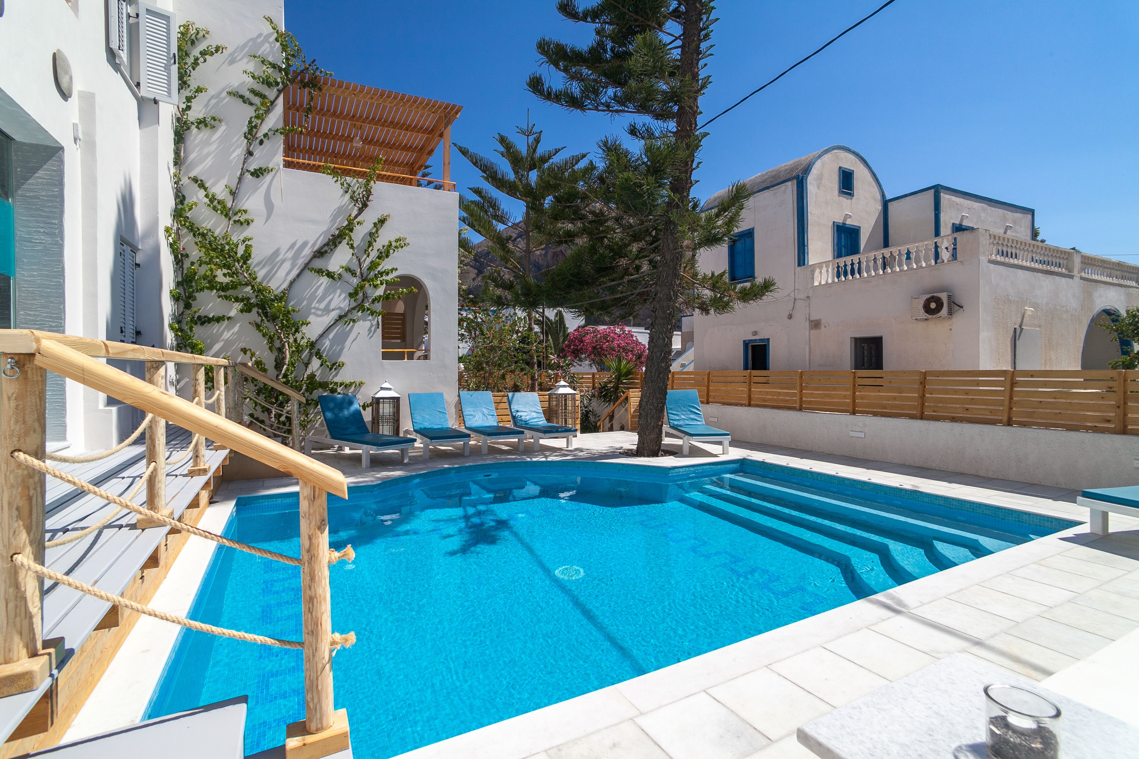 Une piscine avec des chaises longues et une terrasse en bois.