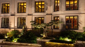 A building with multiple windows, a well-maintained garden with a bonsai tree, and stone planters. - Mulino Luxury Boutique Hotel (Buje)