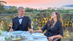 A couple dining outdoors with a scenic view at sunset. - Mulino Luxury Boutique Hotel (Buje)