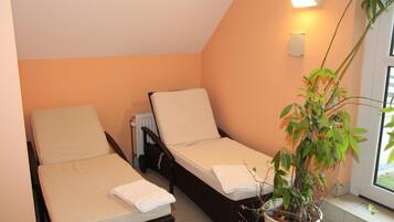 Cozy retreat with two single beds, a radiator, and a potted plant, offering a clean and minimalistic space.