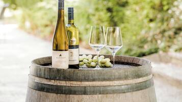 Two wine bottles and two glasses on a wooden barrel.