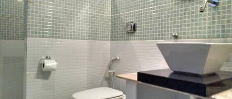 Een badkamer met een toilet, een wastafel en een douche.