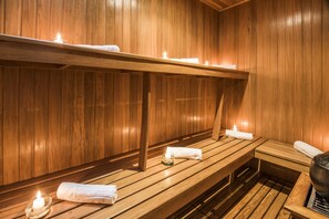 A wooden sauna with benches, candles, and towels. - Travelers Suites Edificio Fontana Plaza (Bogotá)