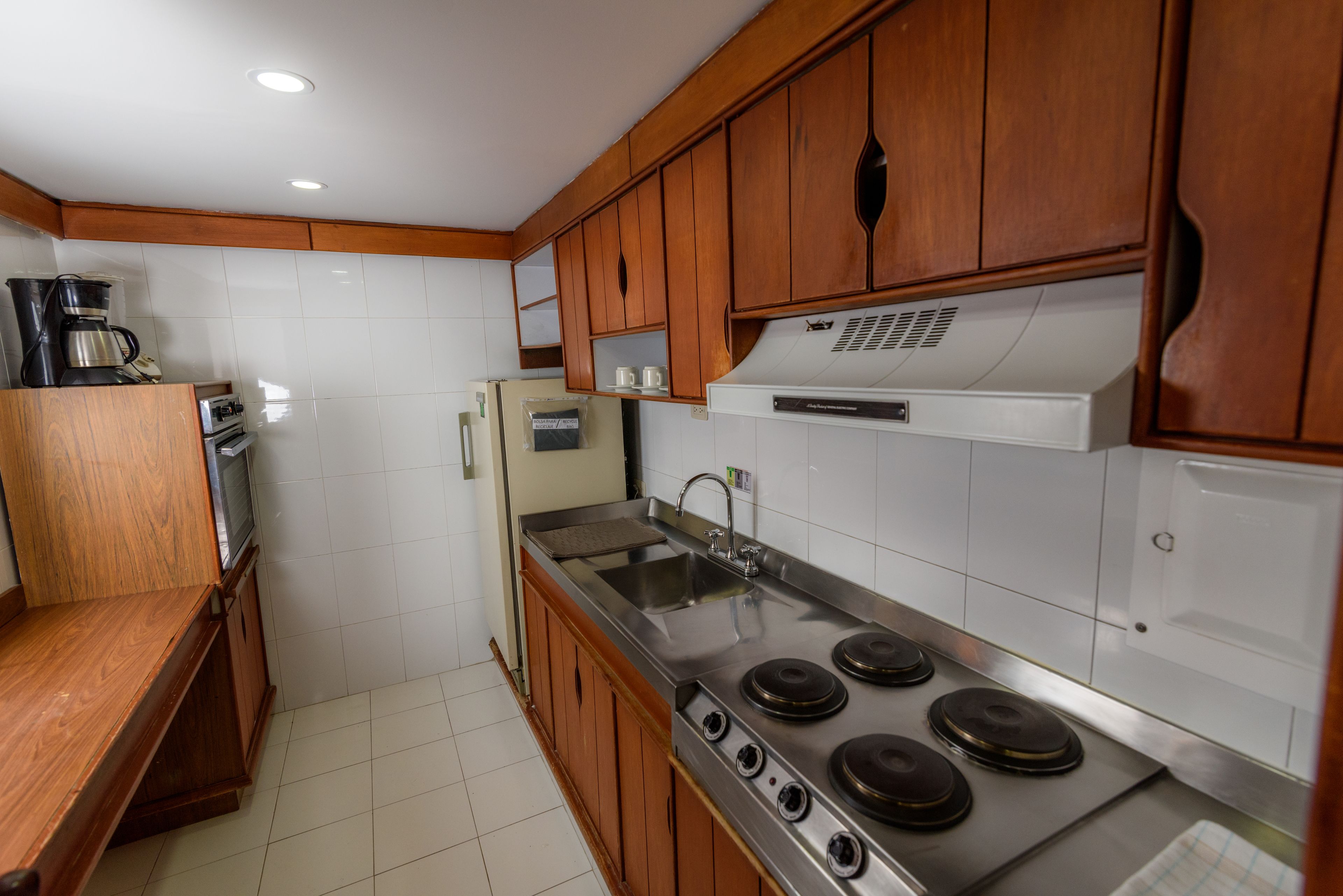 A kitchen with wooden cabinets, a stainless steel stove, and a refrigerator.